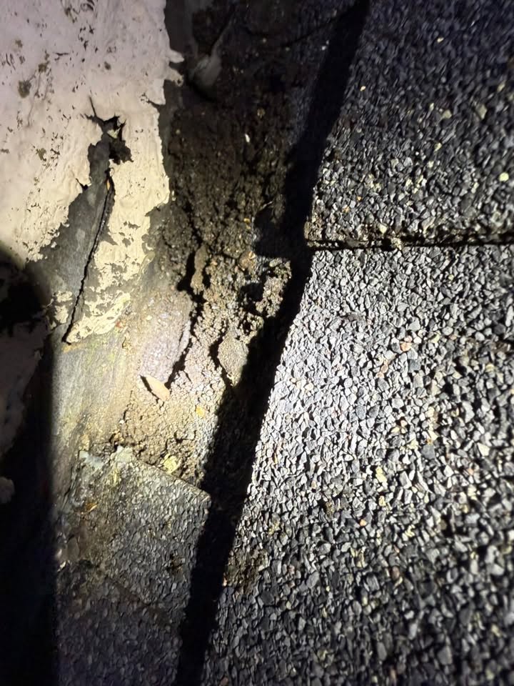 Close view of roof shingles and flashing where the roof meets the wall